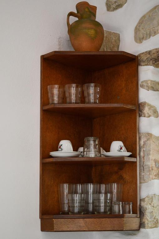 a wooden shelf with dishes and a vase on it at Villa Peristeri in Agios Georgios