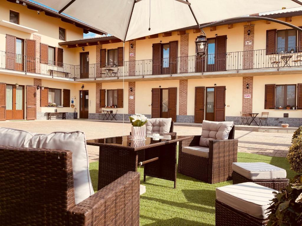 un patio al aire libre con sillas y sombrilla en Agriturismo Cascina Mariale, en Albiano dʼIvrea