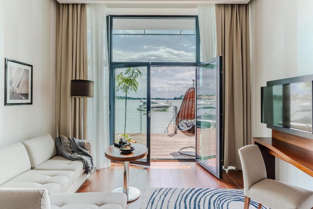 a living room with a large glass door leading to a deck at Hotel Mikołajki Leisure &amp; SPA in Mikołajki