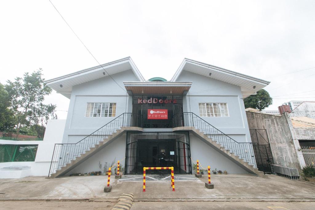 un edificio bianco con una scala di fronte di RedDoorz at V-Cloud Hills near De La Salle Dasmarinas Cavite a Dasmariñas