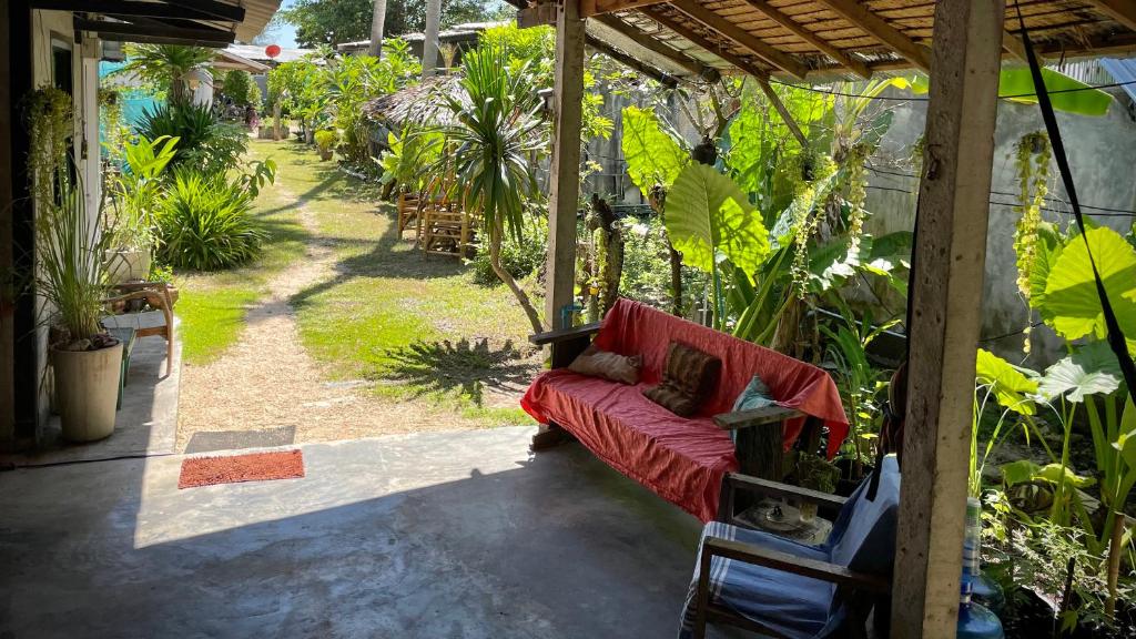 a red couch sitting on a porch with plants at Ozone Beach House in Ko Lanta
