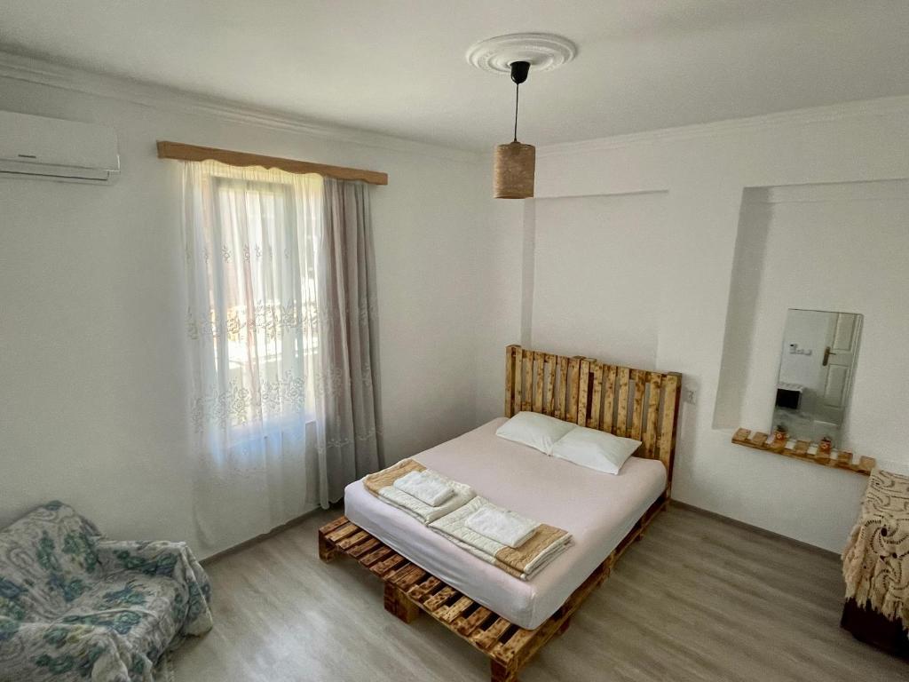 a bedroom with a bed and a chair and a window at 4 Brothers in Kutaisi