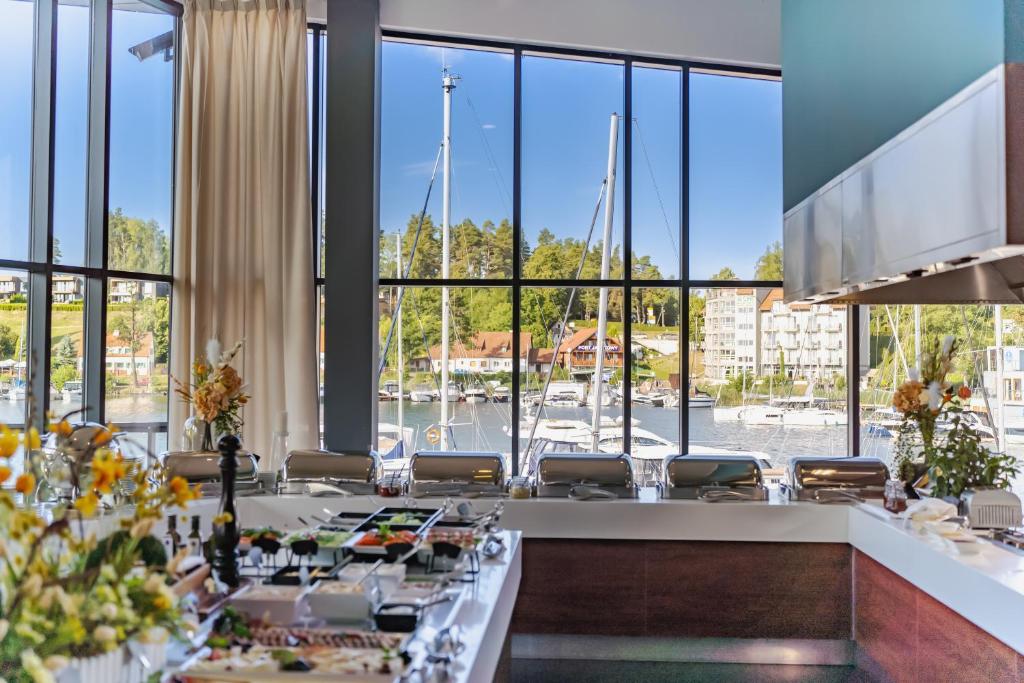 a dining room with a view of a marina at Hotel Mikołajki Leisure &amp; SPA in Mikołajki