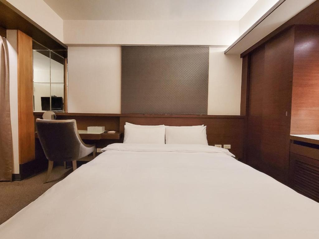 a bedroom with a large bed and a desk at CHECK inn Express Taichung Fengchia in Taichung