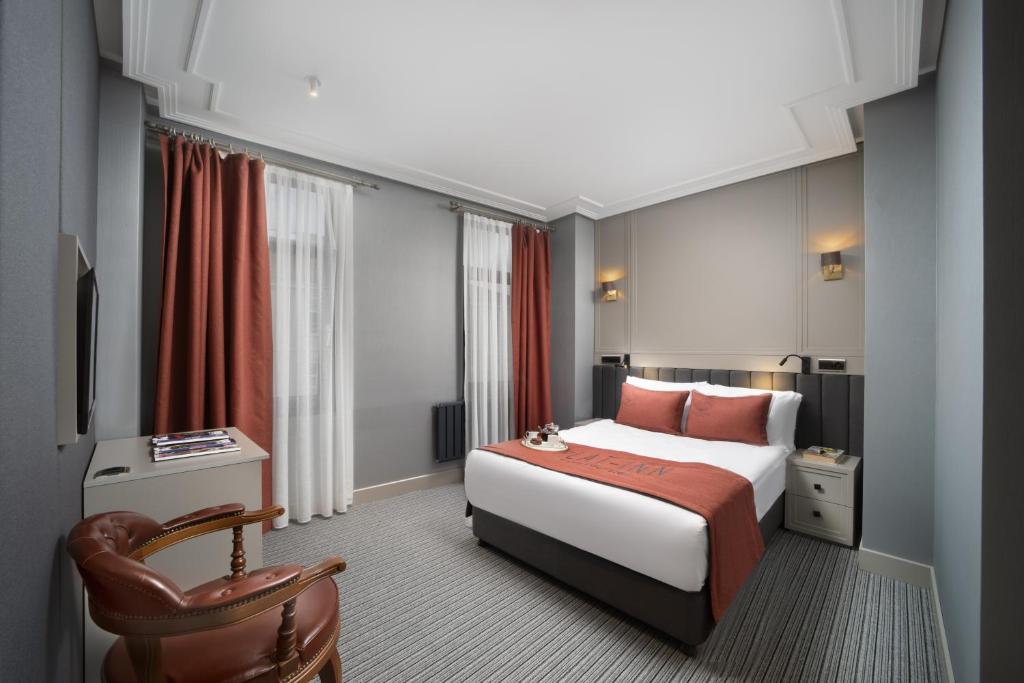 um quarto de hotel com uma cama e uma cadeira em Plat Inn Hotel Taksim em Istambul