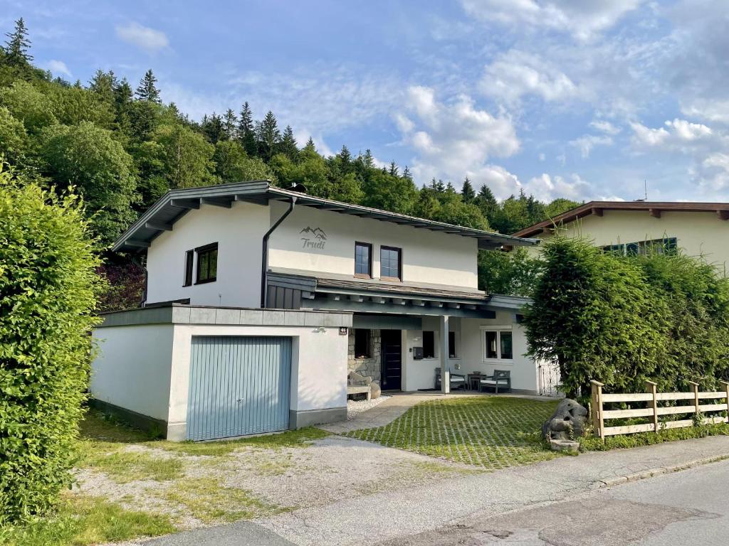 una casa blanca con una puerta y una valla en Haus Trudi en Walchsee