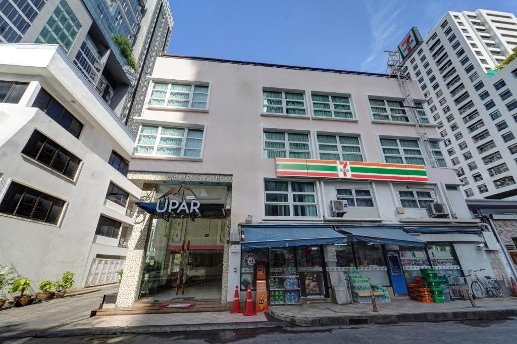 曼谷UPAR Hotels Sukhumvit 11 Nana的街上有商店的白色建筑