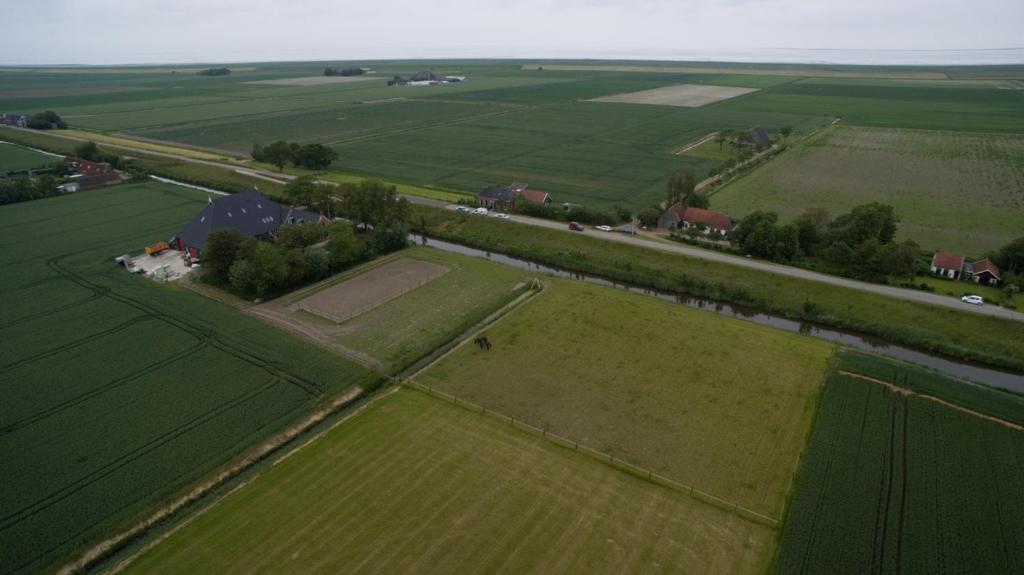 uma vista aérea de um campo com uma casa nele em Bed en Breakfast Panamera em Sint Annaparochie