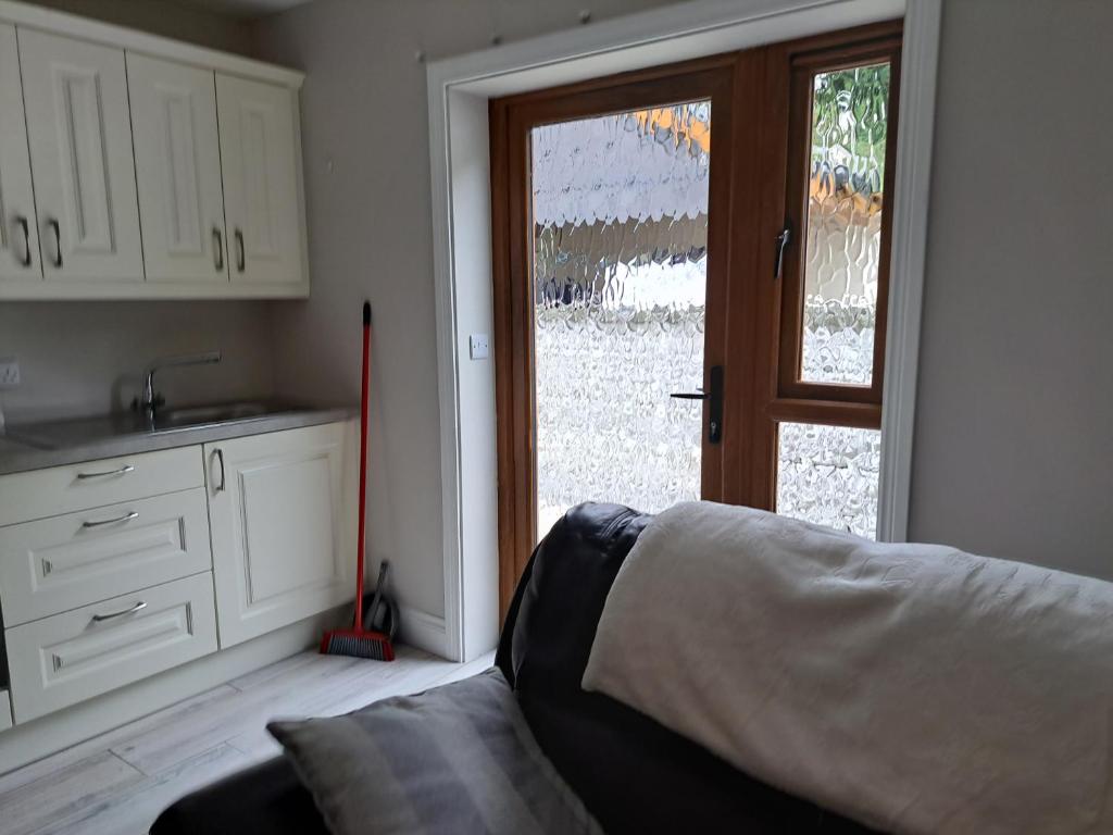 a bedroom with a bed and a sliding glass door at Pollys Haven in Ballybrack