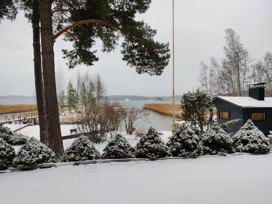 a garden covered in snow with a tree and a house at Cottage by the sea in Turku