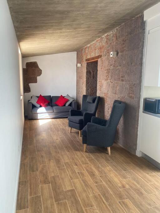 uma sala de estar com um sofá e duas cadeiras em Apartamento Mirador del Almendro em Tejeda