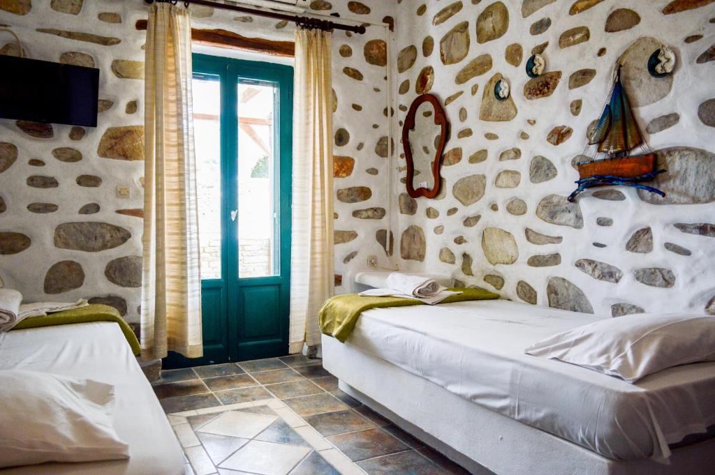 a living room with a couch in a room with stone walls at Villa Peristeri in Agios Georgios