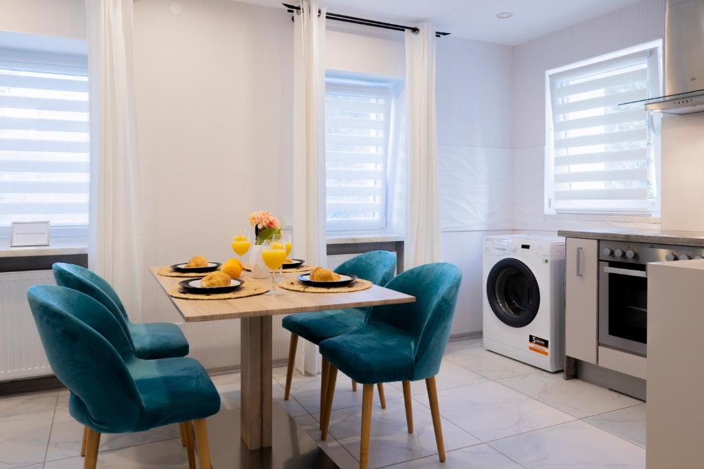 a kitchen with a table and chairs and a microwave at Design Apartment-bis 4 Pers-Vollwertige Küche-Parkplatz-WiFi-Garten-Terrasse in Schiffweiler