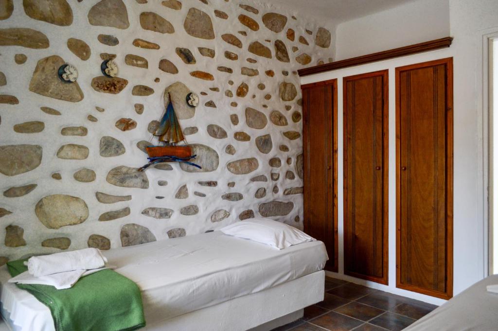 a bedroom with a stone wall with a bed at Villa Peristeri in Agios Georgios
