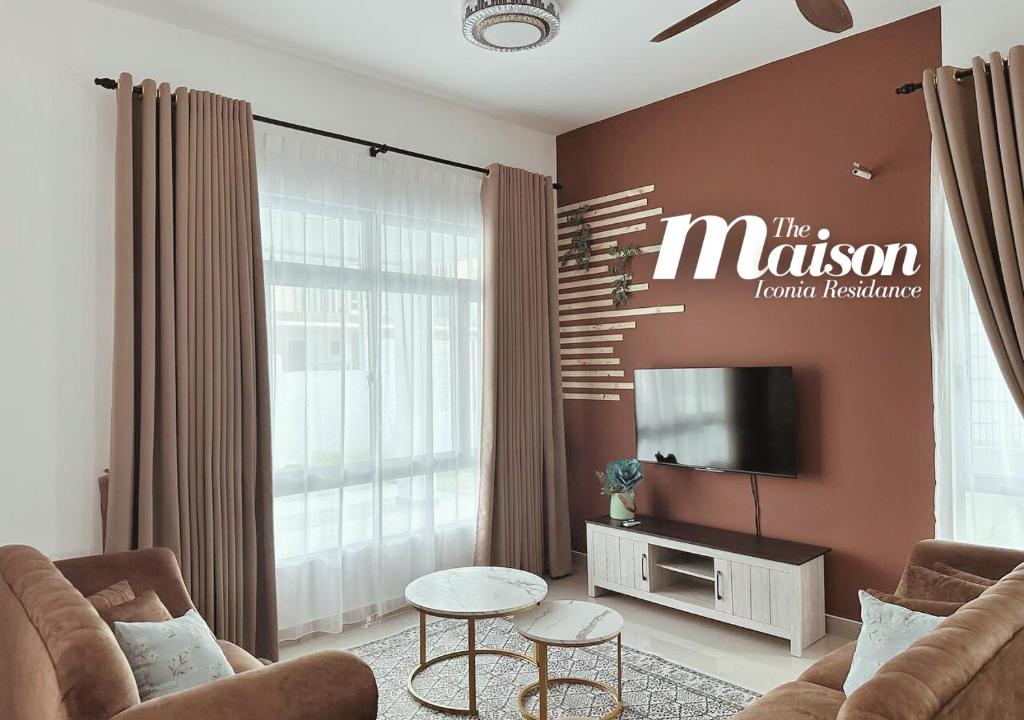 a living room with two chairs and a television at MaisonStay, Iconia Residance, Johor Bahru in Johor Bahru