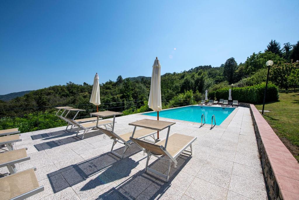 una piscina con mesas y sombrillas junto a en 202 - Camera Mansardata tra le Cinque Terre e Portofino - Residence Cherry House en Carro
