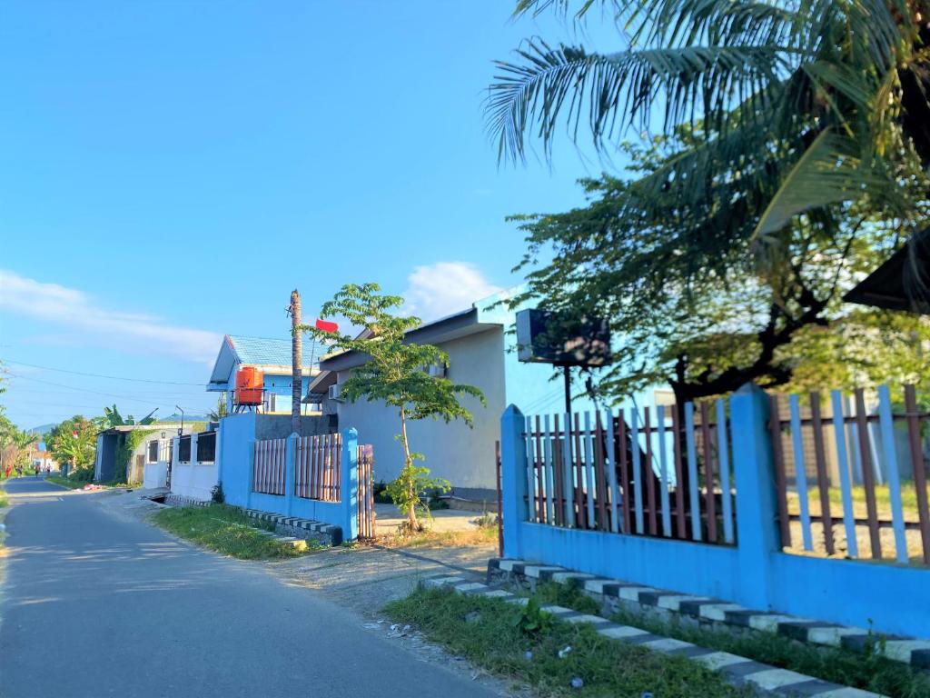 una valla azul al lado de una calle en RedDoorz @ Wisma Sentosa Palopo en Palopo