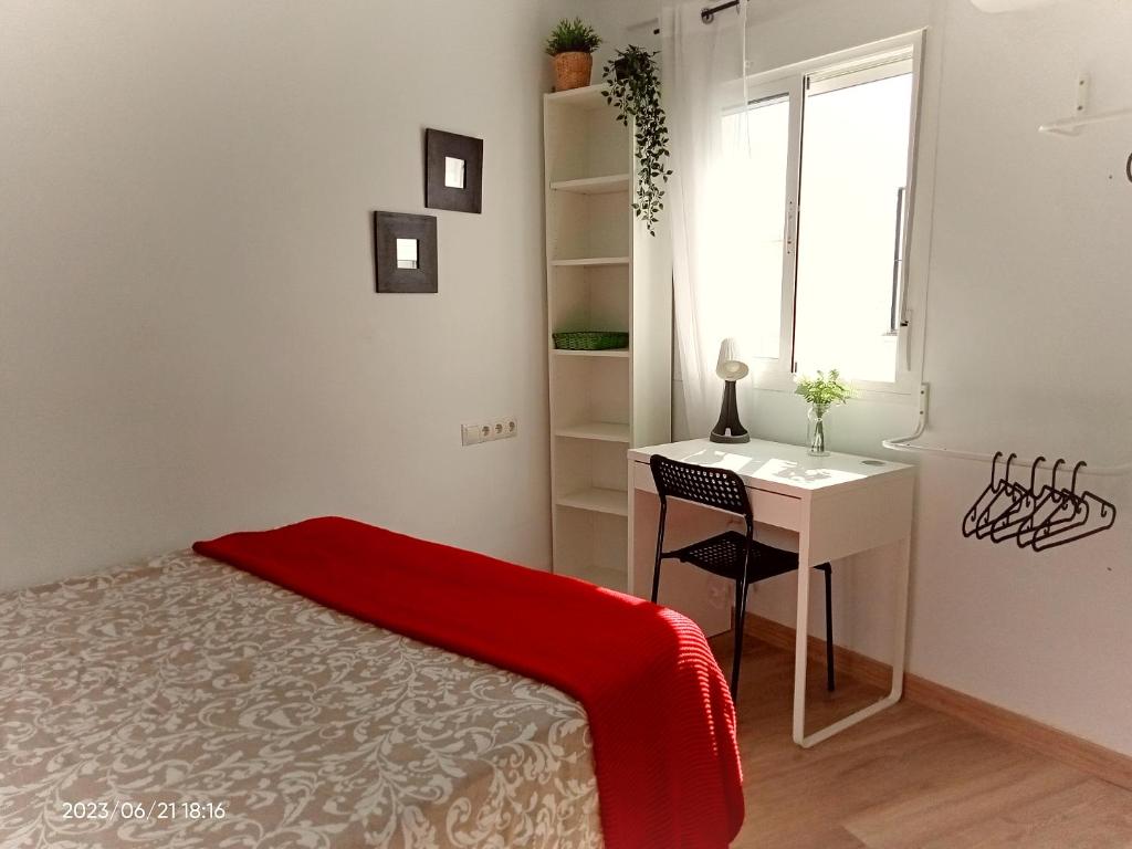 1 dormitorio con cama, escritorio y ventana en Luminosa habitación, en Sevilla