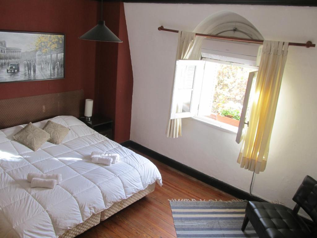 a bedroom with a white bed and a window at Alojarte Mendoza in Mendoza