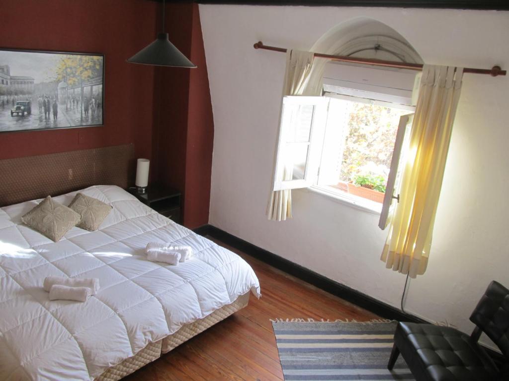 1 dormitorio con cama blanca y ventana en Alojarte Mendoza en Mendoza