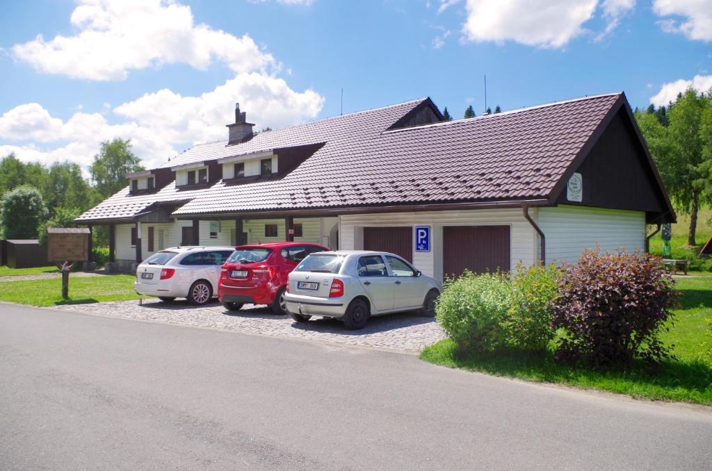 tres autos estacionados frente a una casa en Pension Sport Ostružná en Ostružná