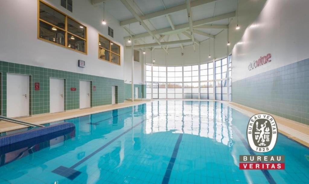 uma grande piscina interior com água azul em Maldron Hotel Portlaoise em Portlaoise