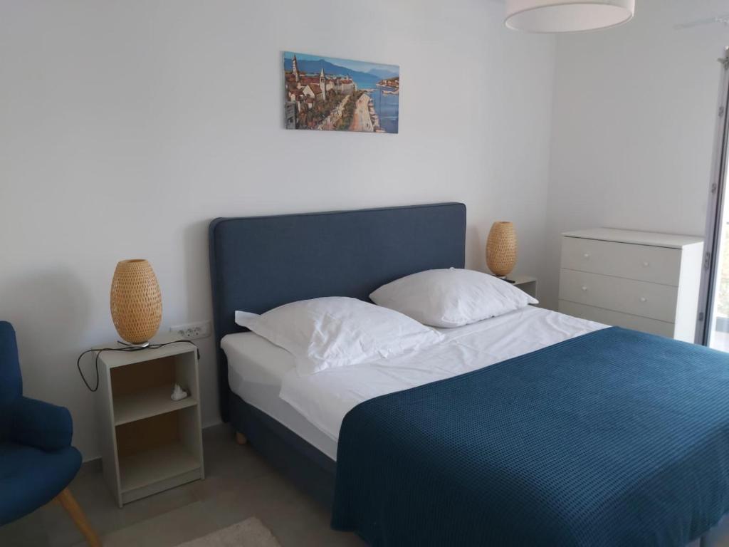 een slaapkamer met een blauw bed en een stoel bij Apartmant Sea View in Poljica