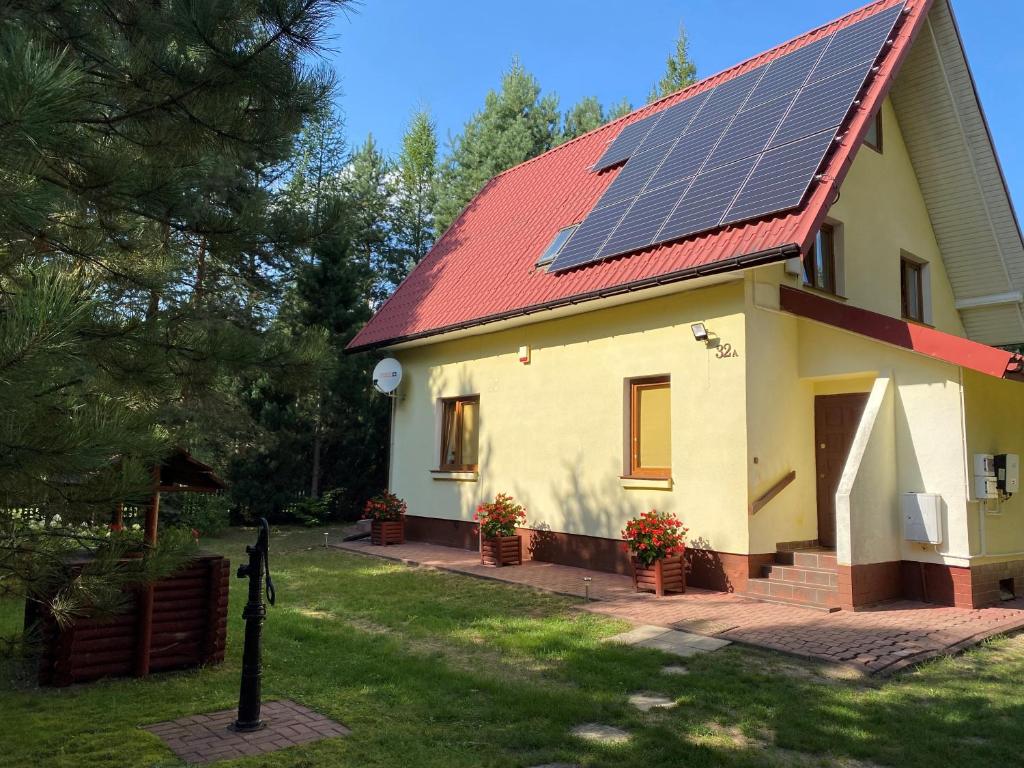 ein Haus mit Sonnenkollektoren auf dem Dach in der Unterkunft Domek Letniskowy Zacisze Guciów in Guciów