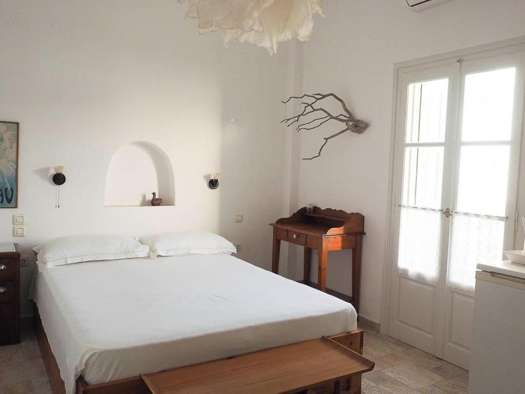 a bedroom with a bed and a table and a window at Anemoessa Studios in Pollonia