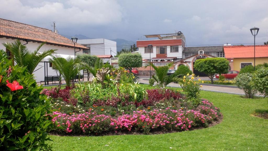 a garden with flowers in the middle of a street at Hostal el Parque Tababela in Tababela