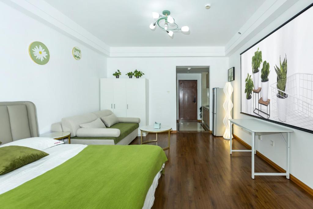 a bedroom with a green bed and a couch at Dalian Hong Xi Yuan Apartment Wanda Plaza in Dalian