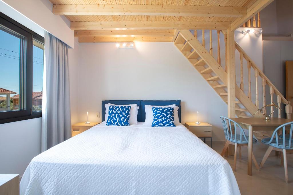 una camera da letto con un letto con cuscini blu e una scala di Zisis Suites a Nydri