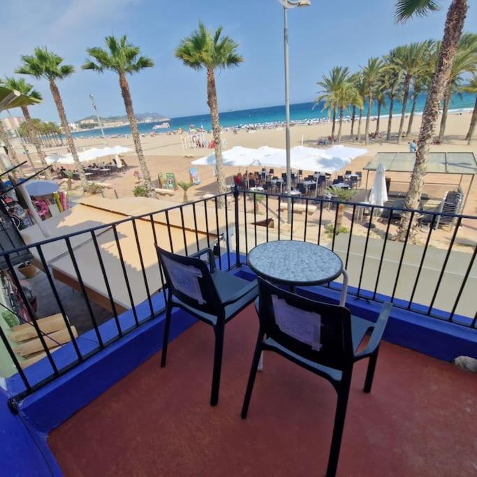 a balcony with a table and chairs and a beach at Arsenal Azul in Villajoyosa