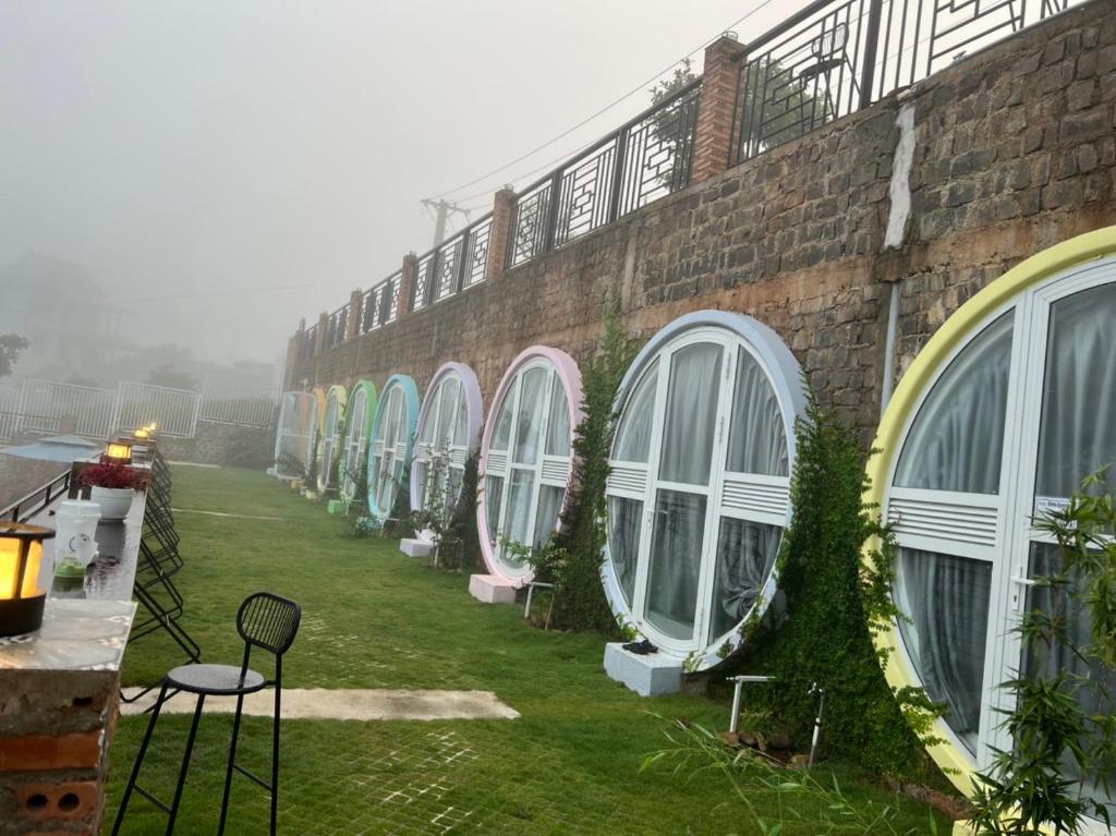 una fila de ventanas en un edificio de ladrillo en METRO HOMESTAY, en Bao Loc