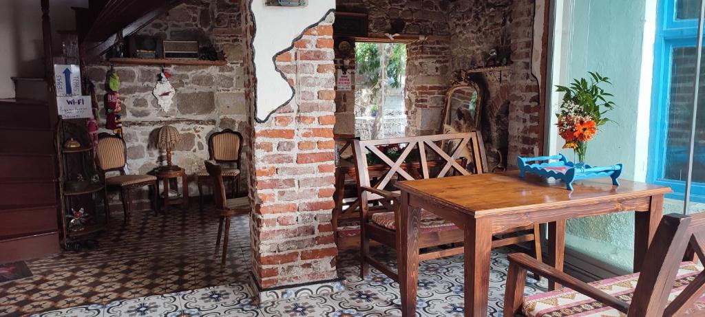 una mesa y sillas en una habitación con una pared de ladrillo en Pergamon pension en Bergama