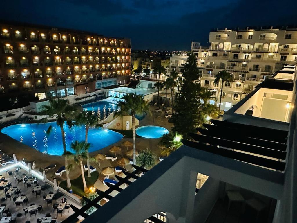 a view of a hotel with a pool at night at Bahía Serena in Roquetas de Mar