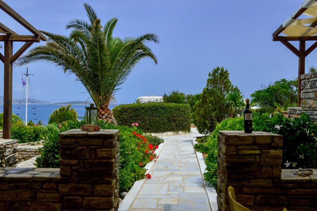 a garden with a stone pathway and a palm tree at Villa Peristeri in Agios Georgios