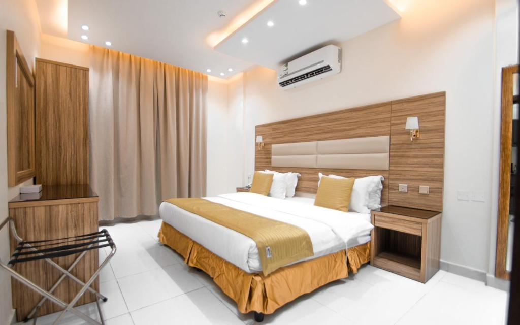 ein Hotelzimmer mit einem Bett und einem TV in der Unterkunft منازل بلقيس للشقق المخدومة in Ha'il
