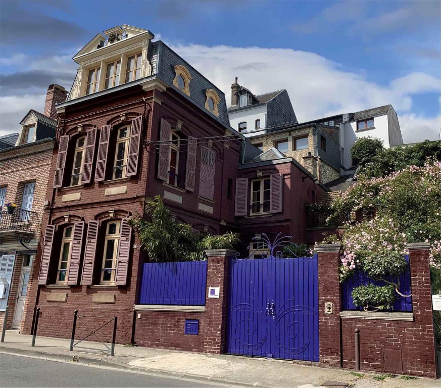 une maison avec une porte bleue devant elle dans l'établissement Purple House, à Saint-Valery-sur-Somme