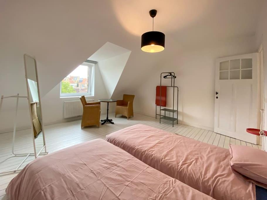 Schlafzimmer mit einem Bett, einem Tisch und einem Fenster in der Unterkunft Kleine Dijk in Diksmuide