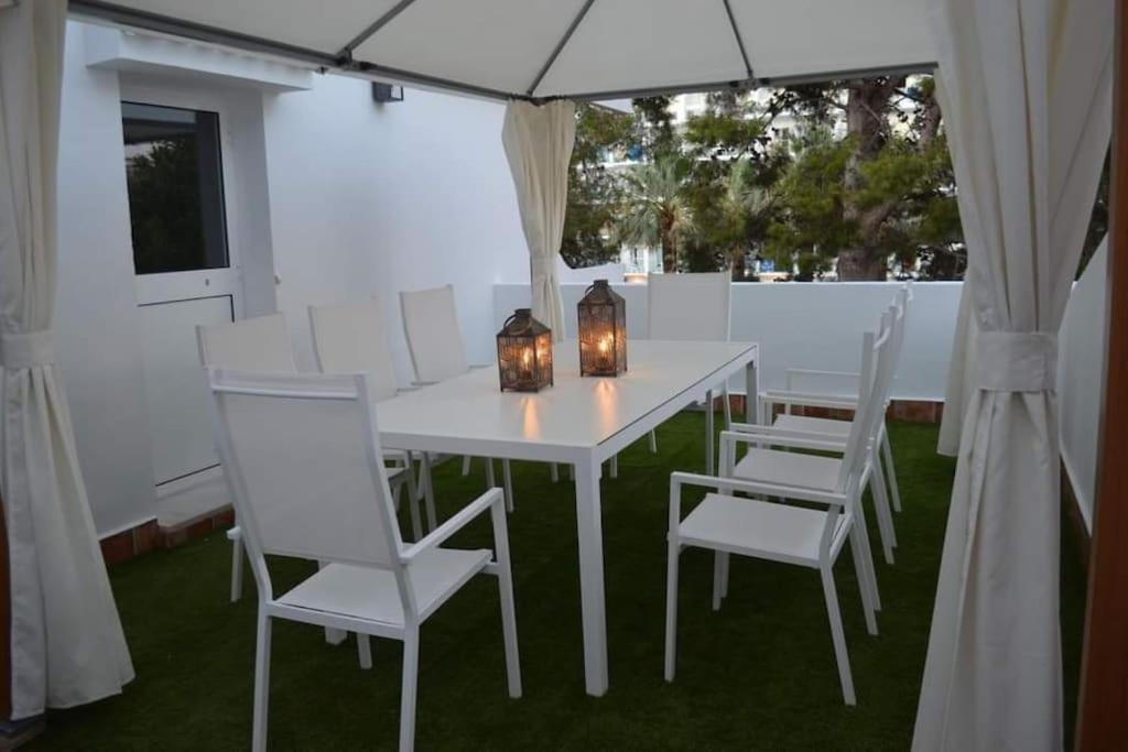 una mesa blanca con sillas blancas y una sombrilla en Golddem Yolamar Benalmadena, en Benalmádena
