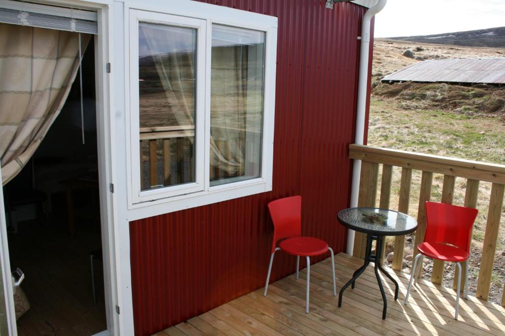 a porch with two chairs and a table and a window at Litlabjarg Guesthouse in Hrafnabjorg