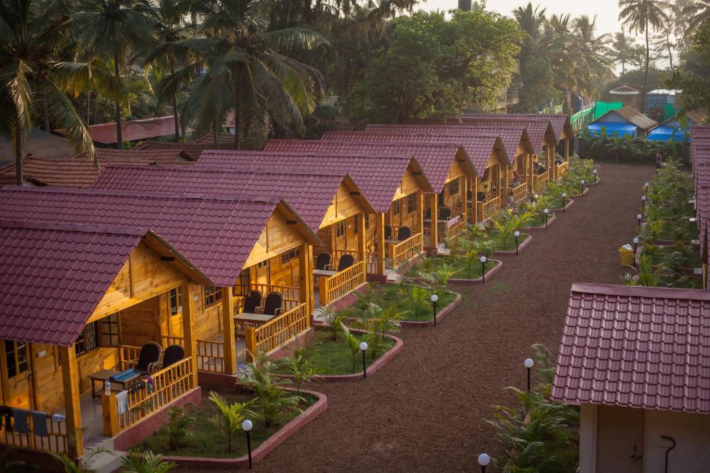 una fila di rifugi in un resort con tetti viola di Zen Cottages ad Agonda