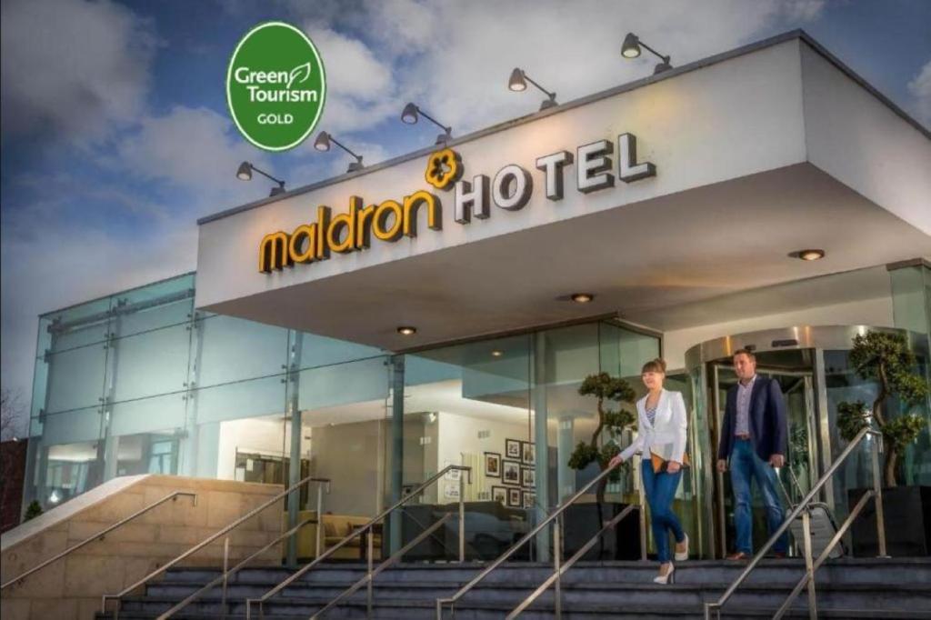 dwóch mężczyzn wychodzących z hotelu Melbourne w obiekcie Maldron Hotel Dublin Airport w mieście Cloghran
