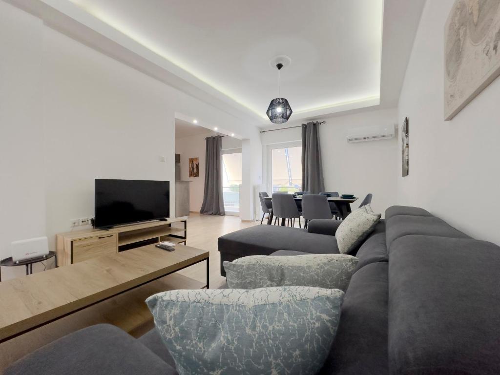 a living room with a couch and a tv at Aristotelous Spacious 109sqm apt in Athens in Athens