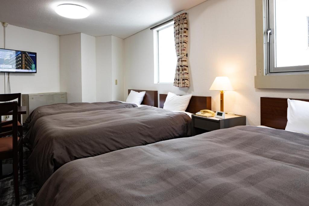 Postel nebo postele na pokoji v ubytování Kurashiki Station Hotel