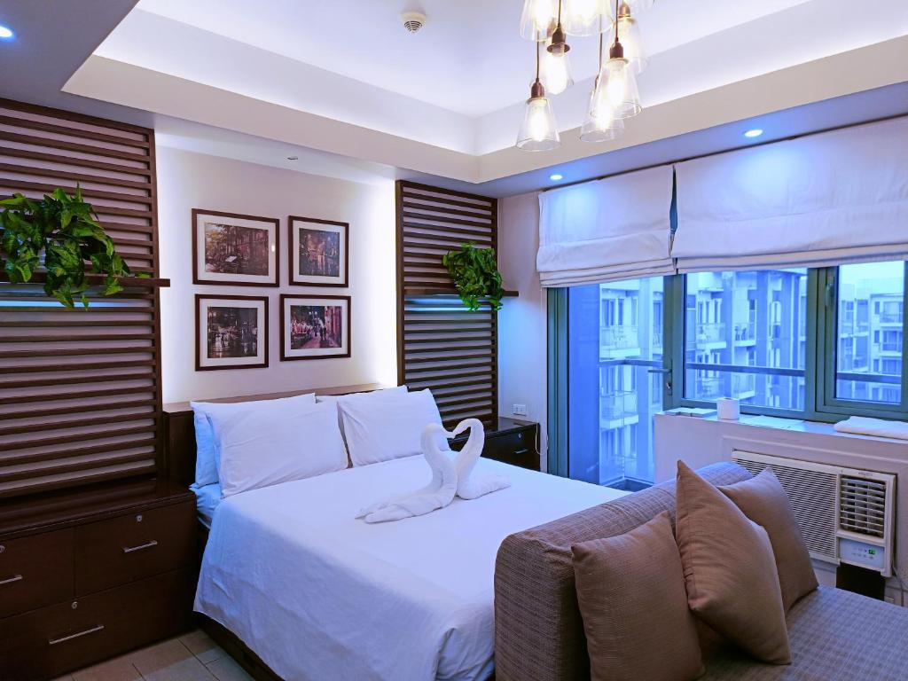 una camera da letto con un letto e un asciugamano bianco di Two Palmtree Villas Across Manila Airport Terminal 3 -JJRMK Condotel a Manila