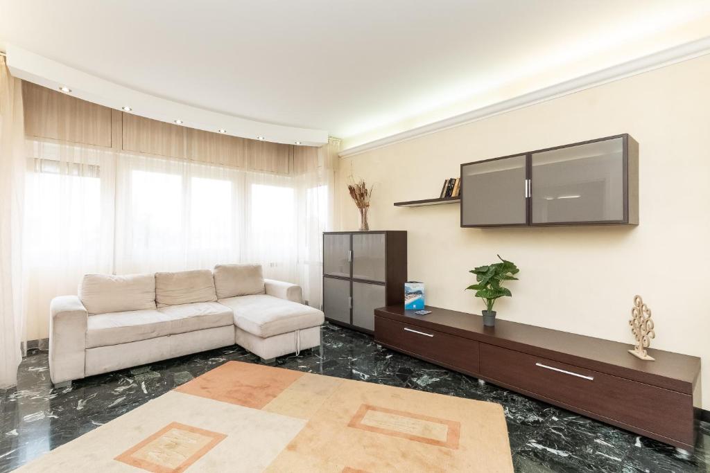 ein Wohnzimmer mit einem Sofa und einem TV in der Unterkunft Oasi di pace a 10 min. dall'aeroporto in Genua