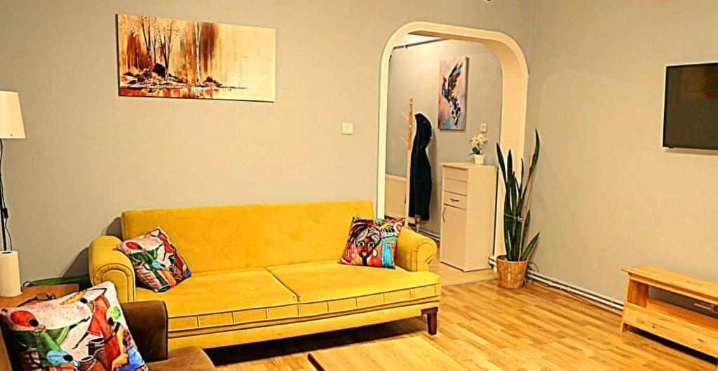 a living room with a yellow couch and a mirror at Kadıköy Yeldeğirmeni'nde daire in Istanbul