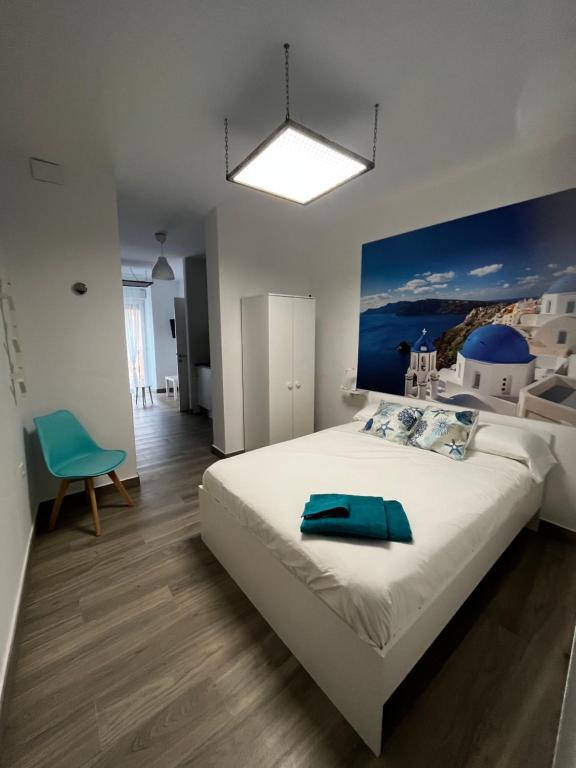 Un dormitorio con una cama grande con una toalla azul. en APARTAMENTOS MAPAMUNDI, en Badajoz